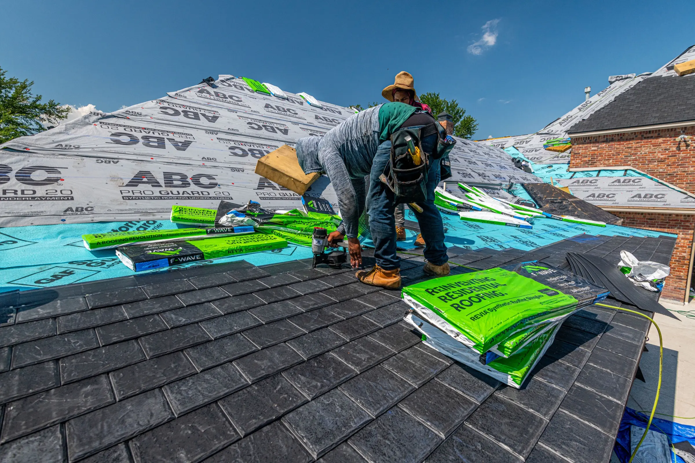 Roofer installing shingles on a pitched roof