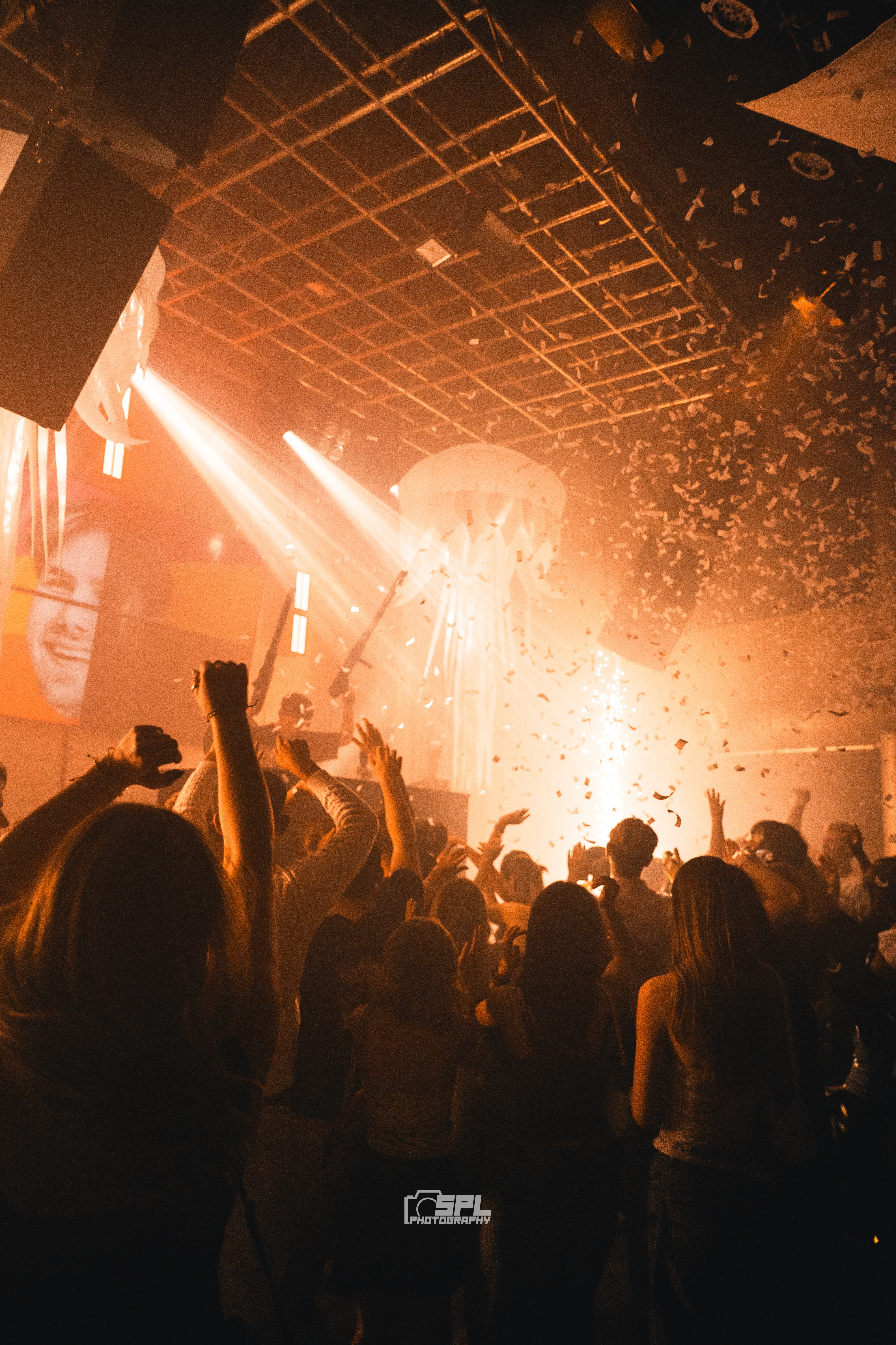 A close-up of a person wearing green-tinted glasses, with a serious expression and smooth skin.