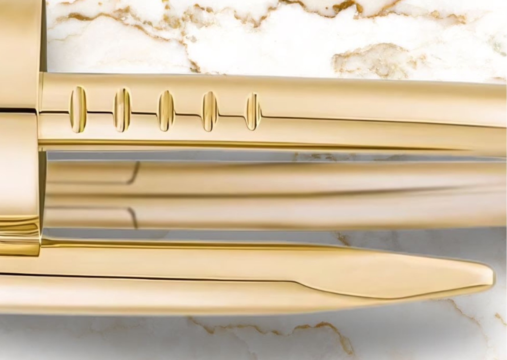 Elegant, classy, luxurious, chic, designer, branded Cartier jewellery in gold, from the Cartier Juste un Clou nail design - against a beige/gold and white marble.