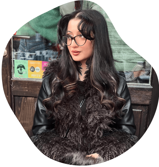 Photo of me sitting outside, in a fur jacket looking to the right.