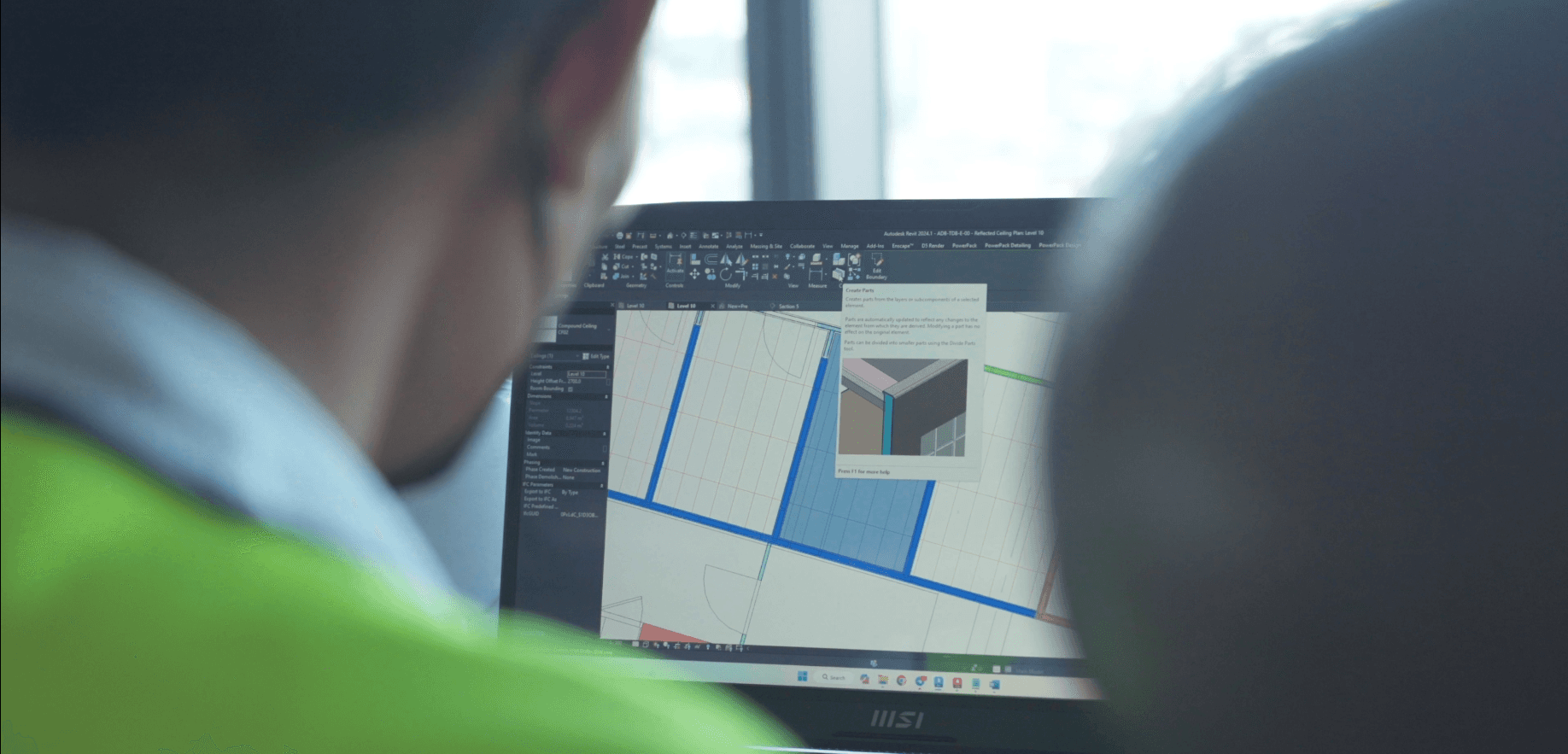 Digital BIM coordination model on a laptop screen during a technical review, representing verifiable design intent and data-driven quality control for complex building systems