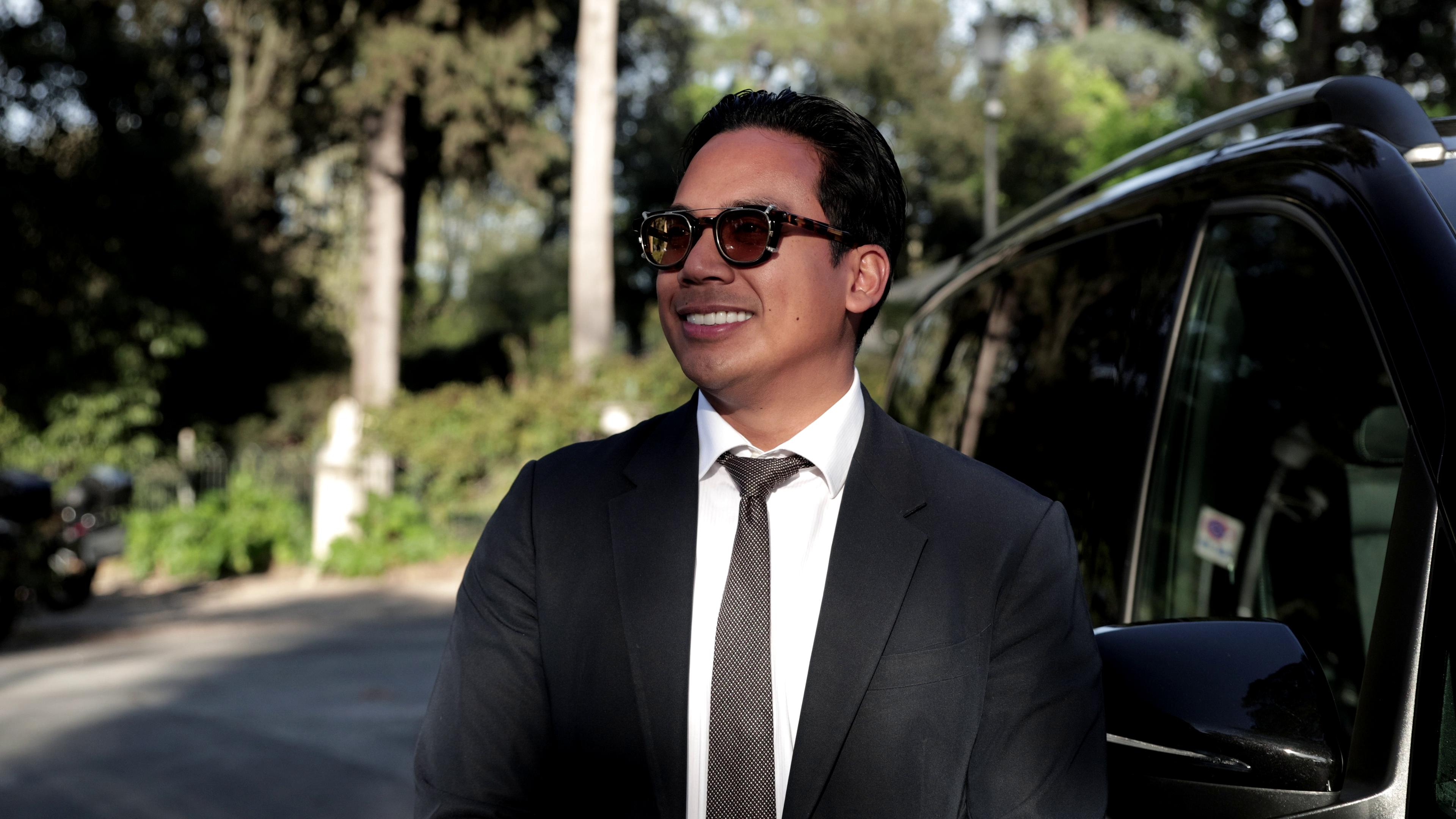 A Chauffeur smiling beside a Mercedes van.