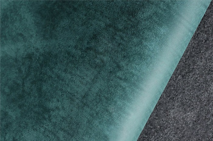 Hand cutting brown leather with precision knife on green cutting mat – leather crafting process