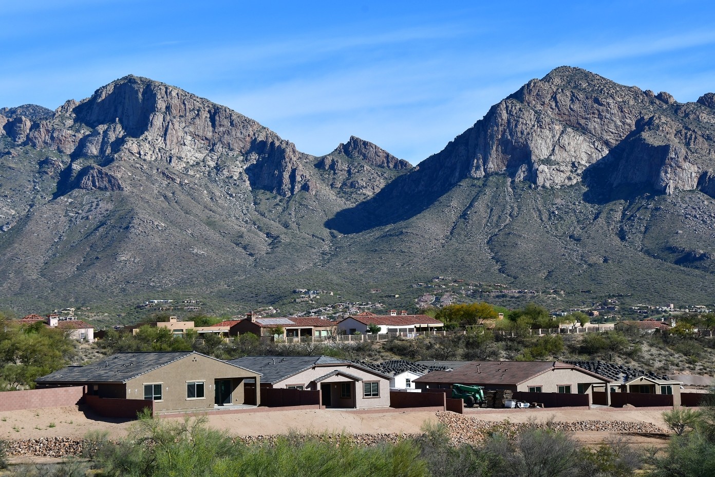 Pusch Ridge Mountains with Homes and a sunny blue sky.