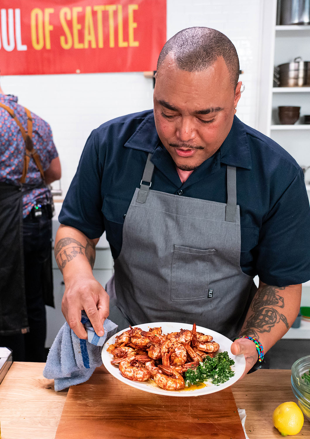 Chef Dre Neely showing off some shrimp that he prepared at the studio kitchen at Particle Studio in Seattle WA.