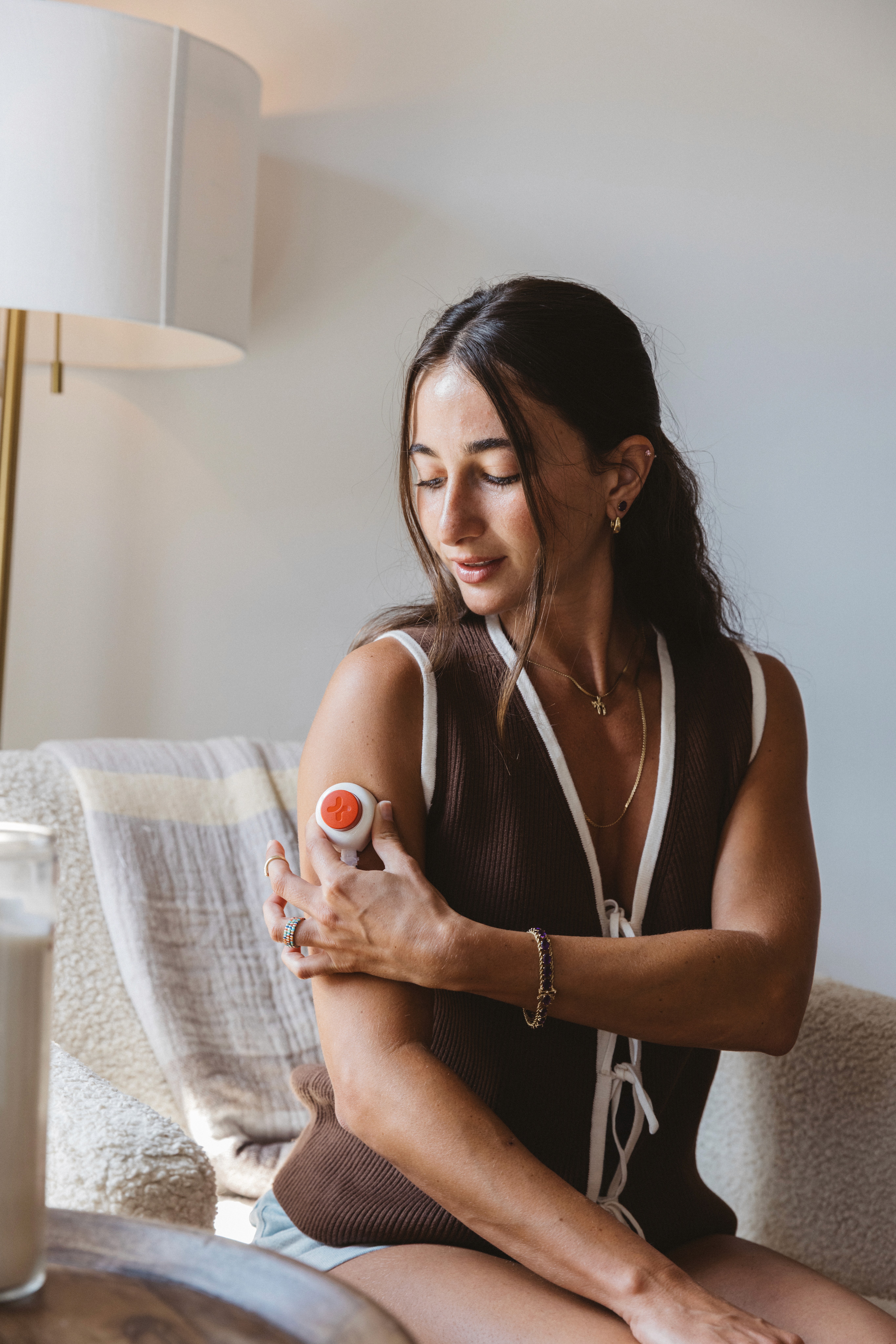 Woman collecting a blood sample from her upper arm at home.