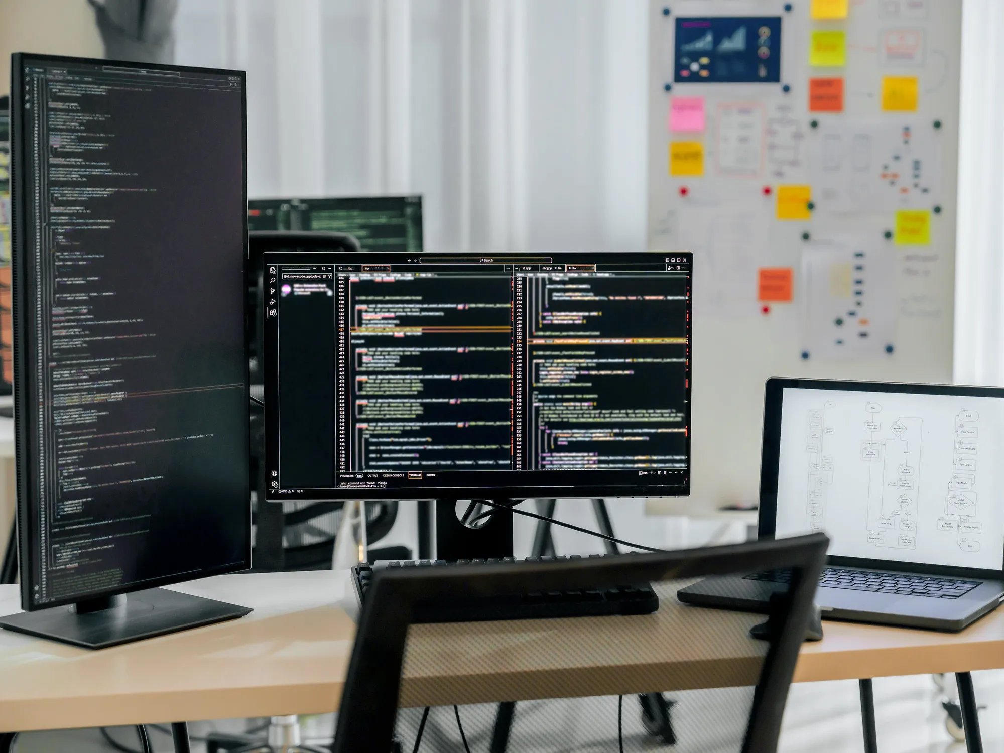 Modern indoor space with large glass doors, lush greenery, and a cozy seating area visible beyond.