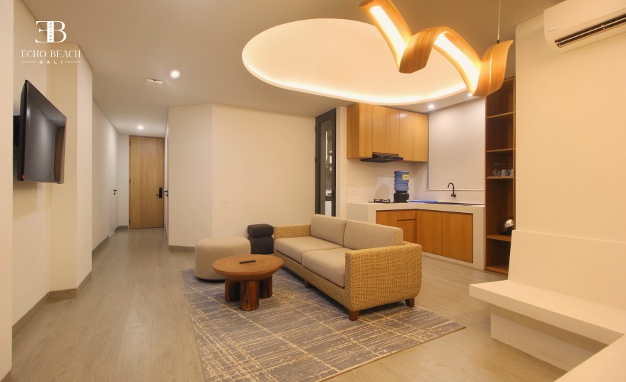 Stylish living room and integrated kitchenette in the Bali Canggu Echo Beach Suite three bathroom apartment, featuring modern design and lighting.