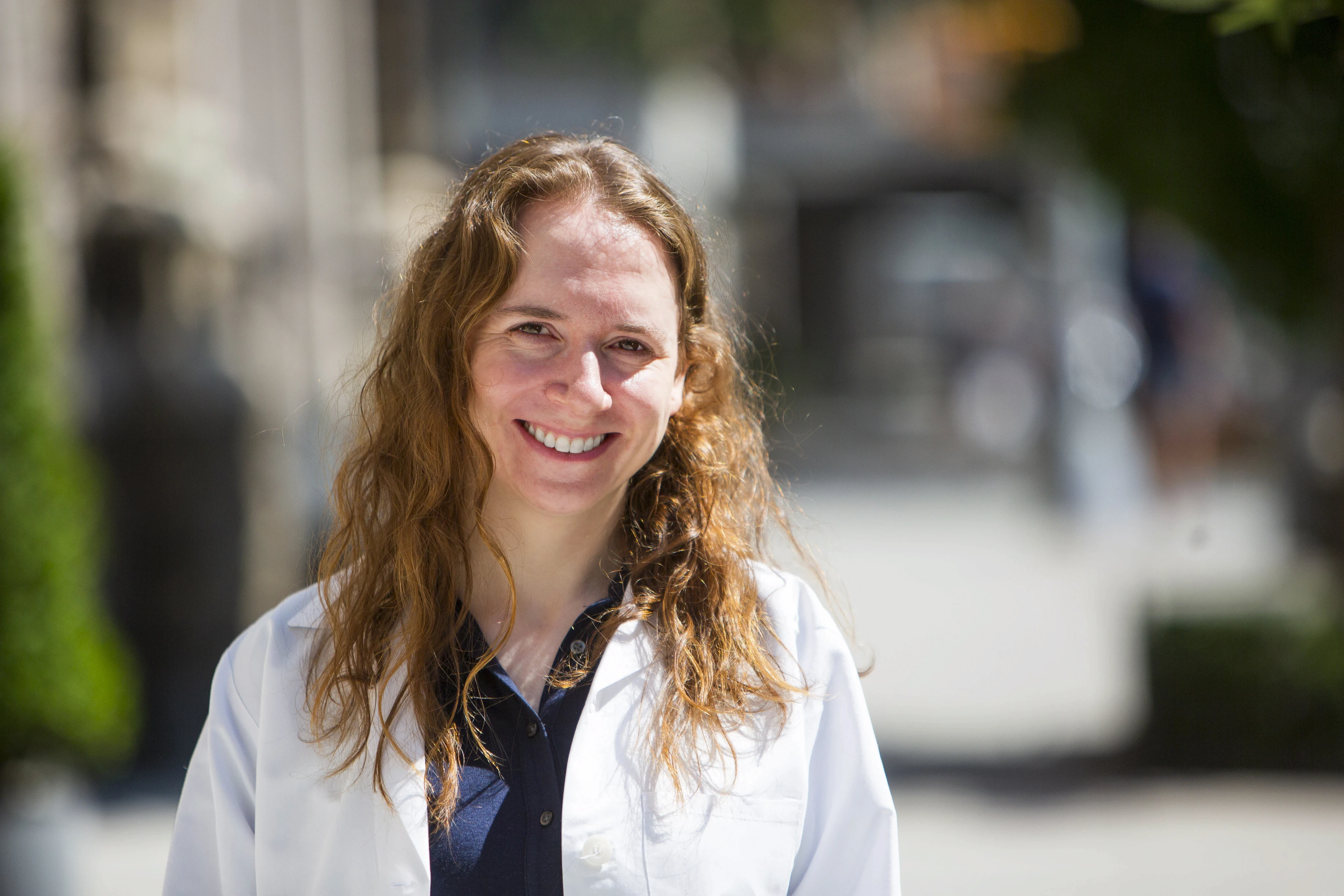 Portrait of a woman with long red hair gently touching her face, looking into the camera