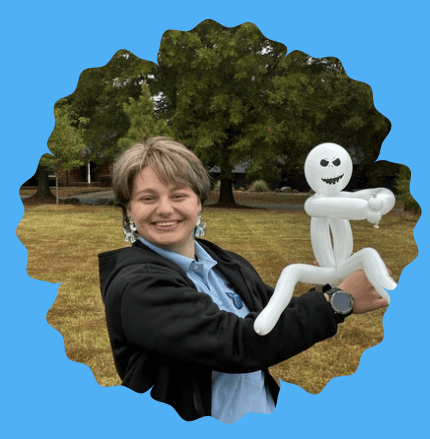 Amelia smiling and posing with a heart wand and flower face paint