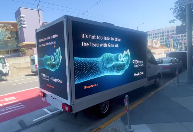A white truck displays a digital billboard ad for Gen AI and Google Cloud, featuring an illustrated robotic hand with text promoting AI leadership.