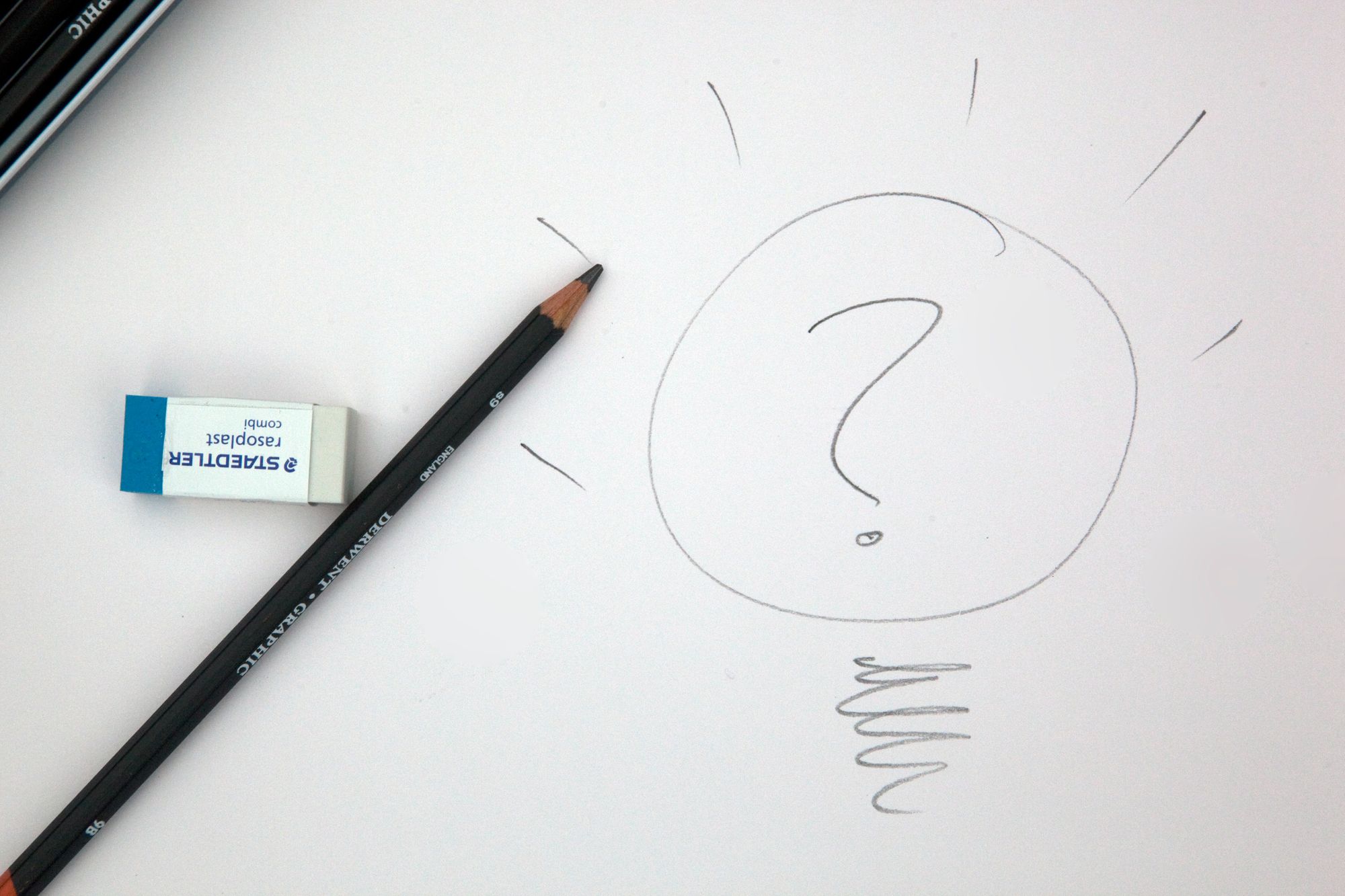 Drawing of a question mark within a lightbulb beside a pencil and eraser