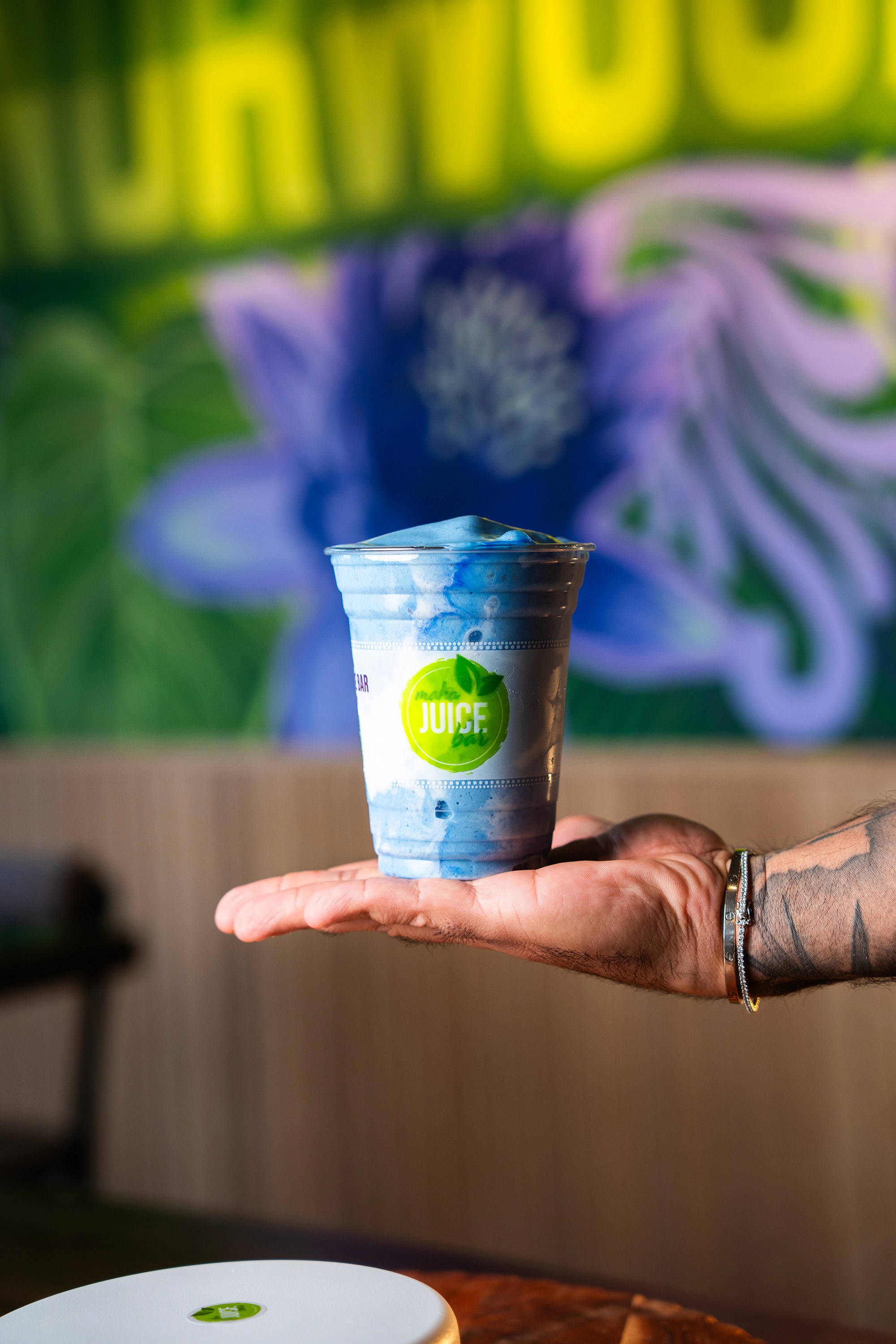 Hand holding Maha Juice smoothie