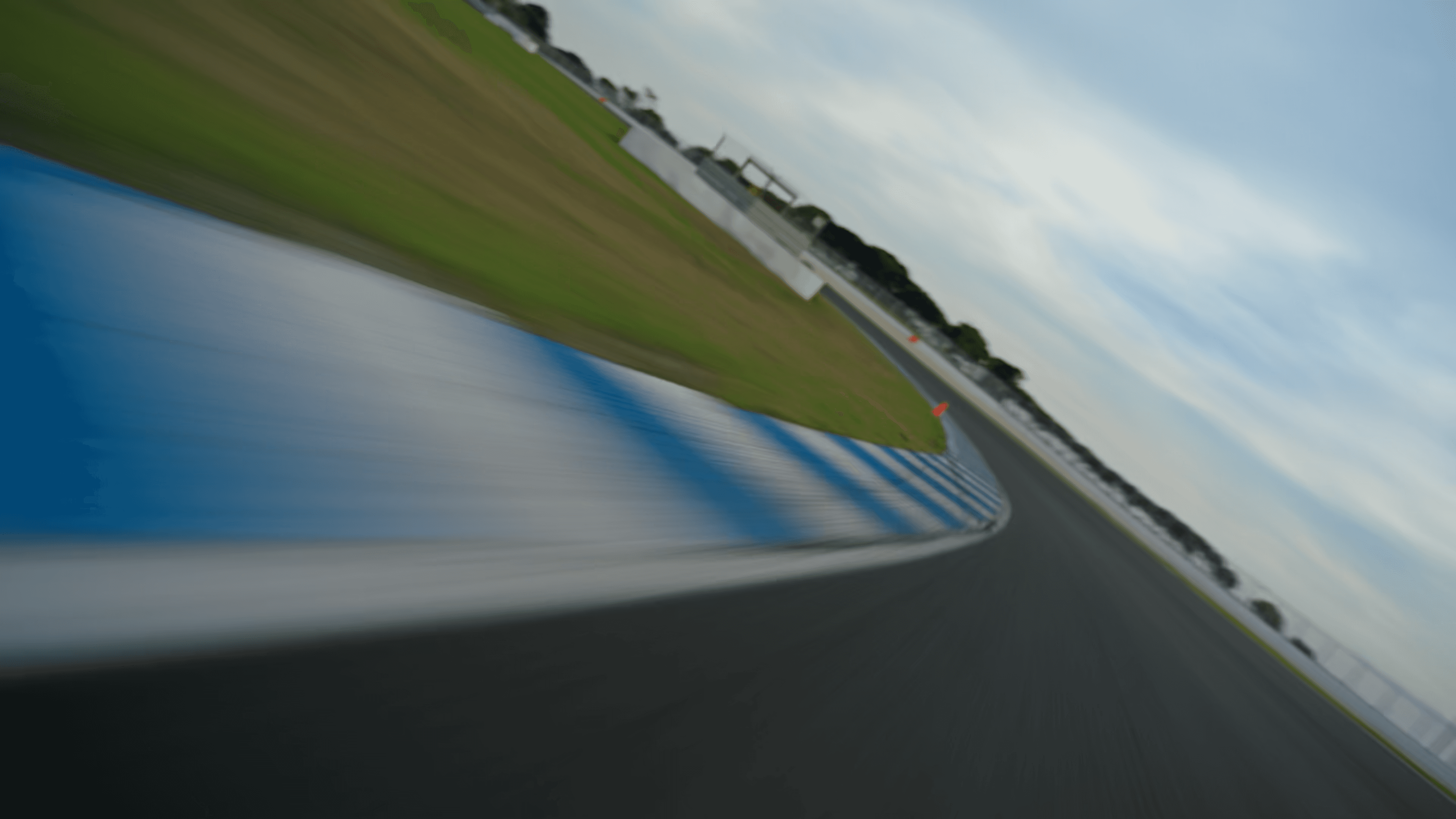 A close-up of a model standing outdoors, with her hand brushing through her hair, framed by a backdrop of city buildings