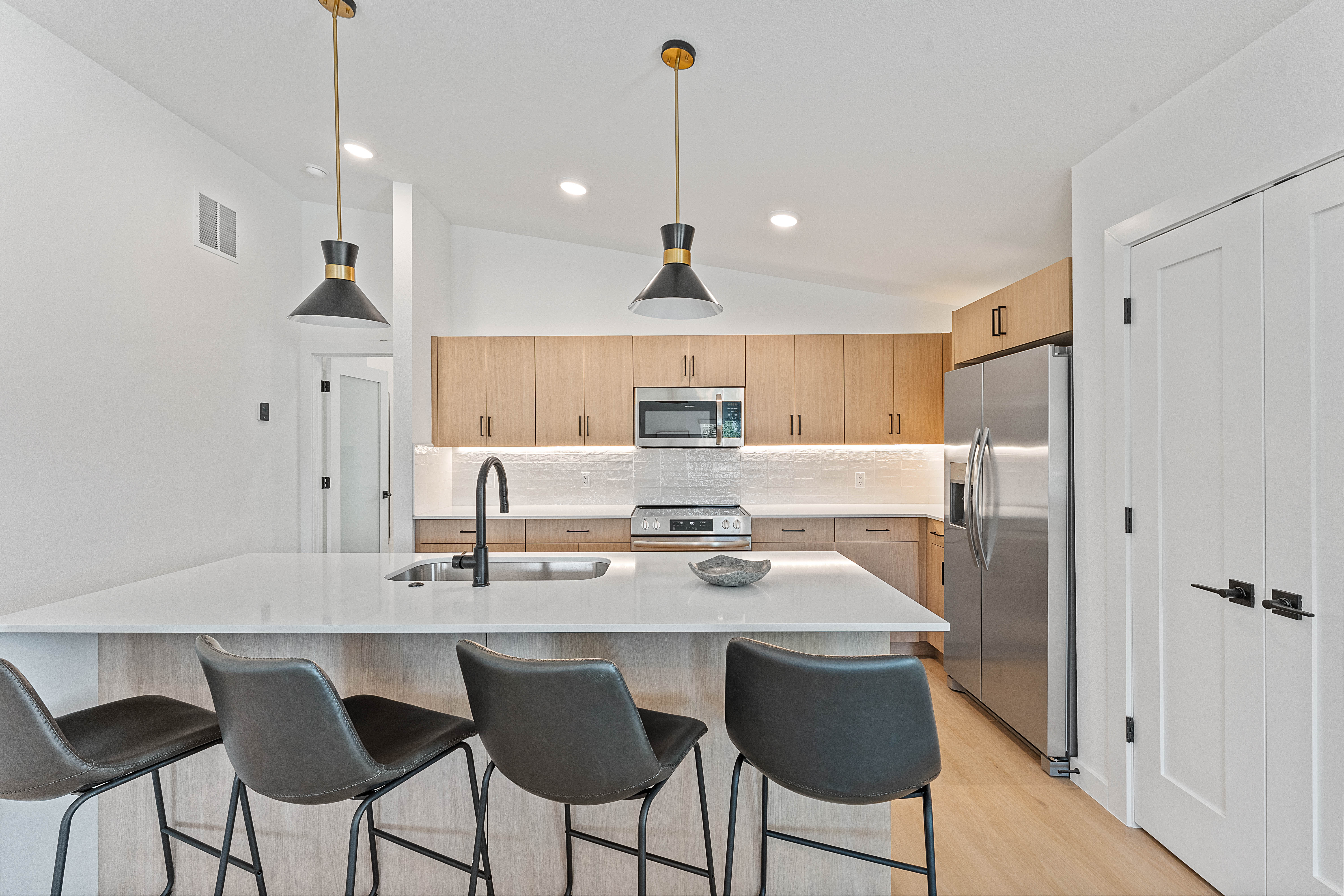 Modern apartment building with blue sky and clouds reflected in windows.