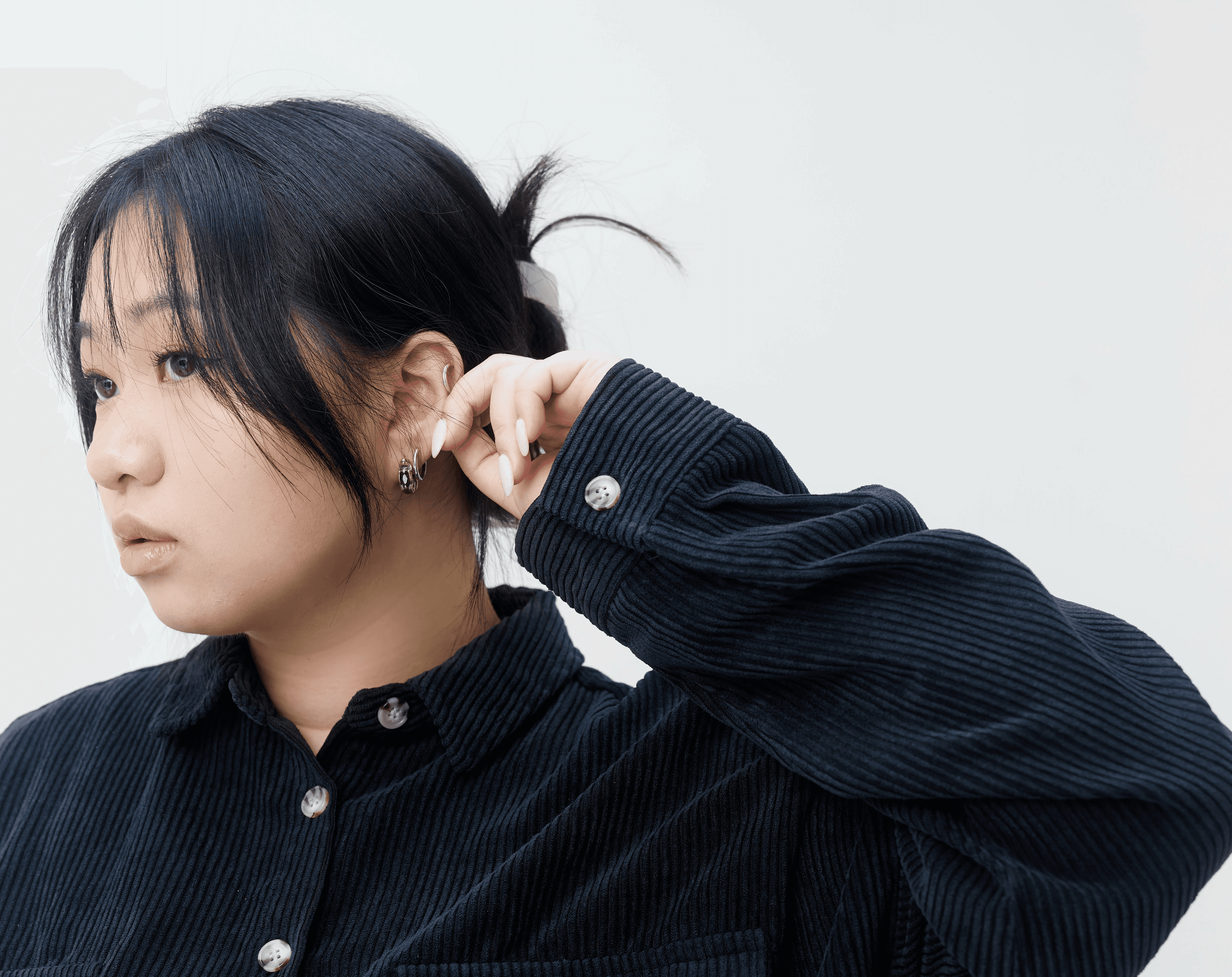 A group of four people engaged in a discussion while seated in a cozy, plant-filled setting.