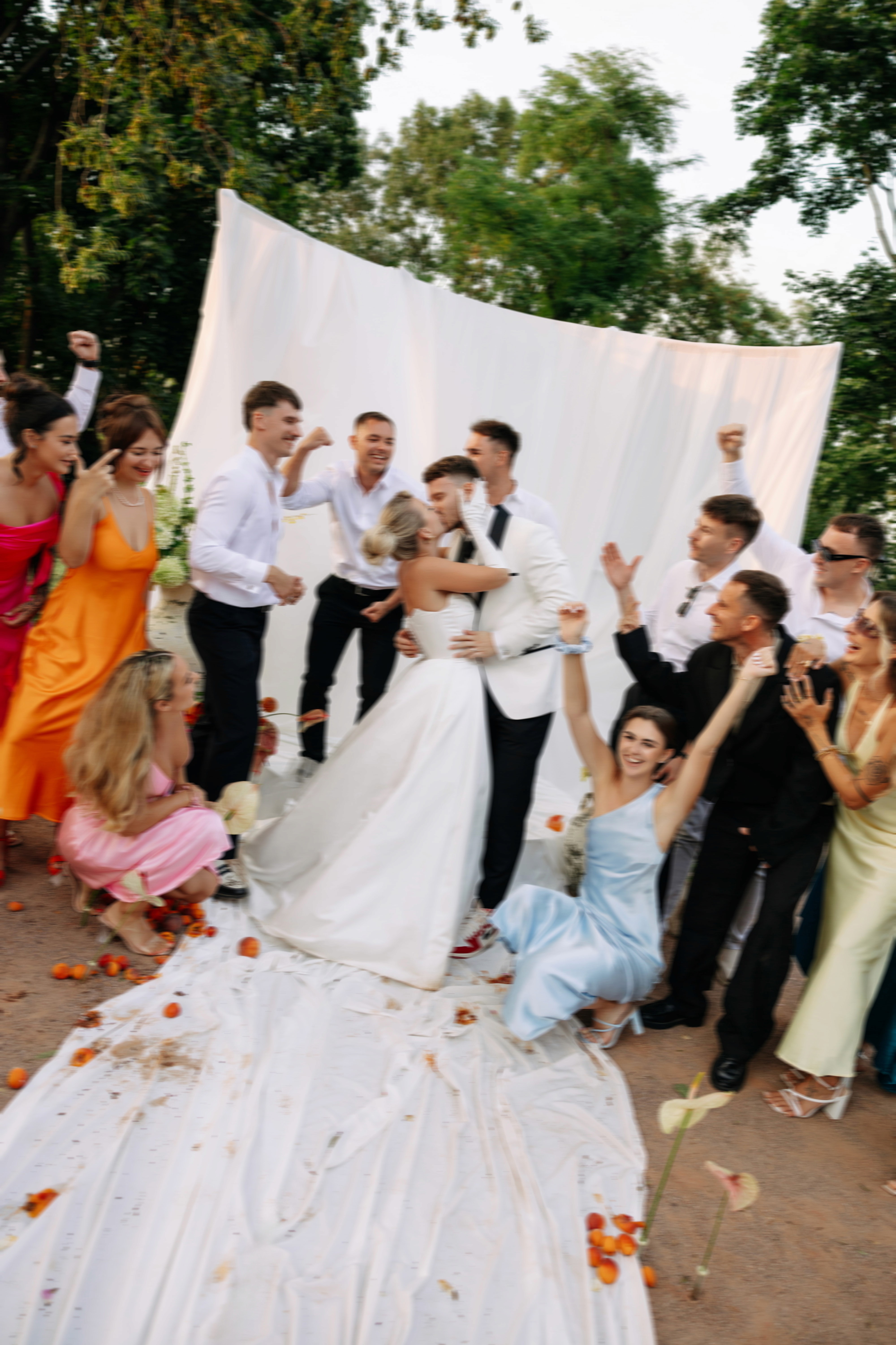 Wedding guests celebrating outdoors at a Tuscan-inspired ceremony — joyful, colourful, alive.