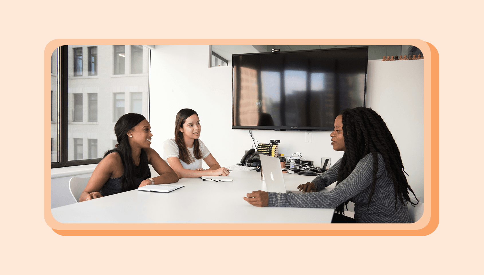 Three people sitting in an official setting and chatting with each other.