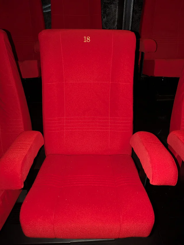 Détail sur un des fauteuils rouge de la salle de projection IO au gîte La Tuilerie du Cinéaste