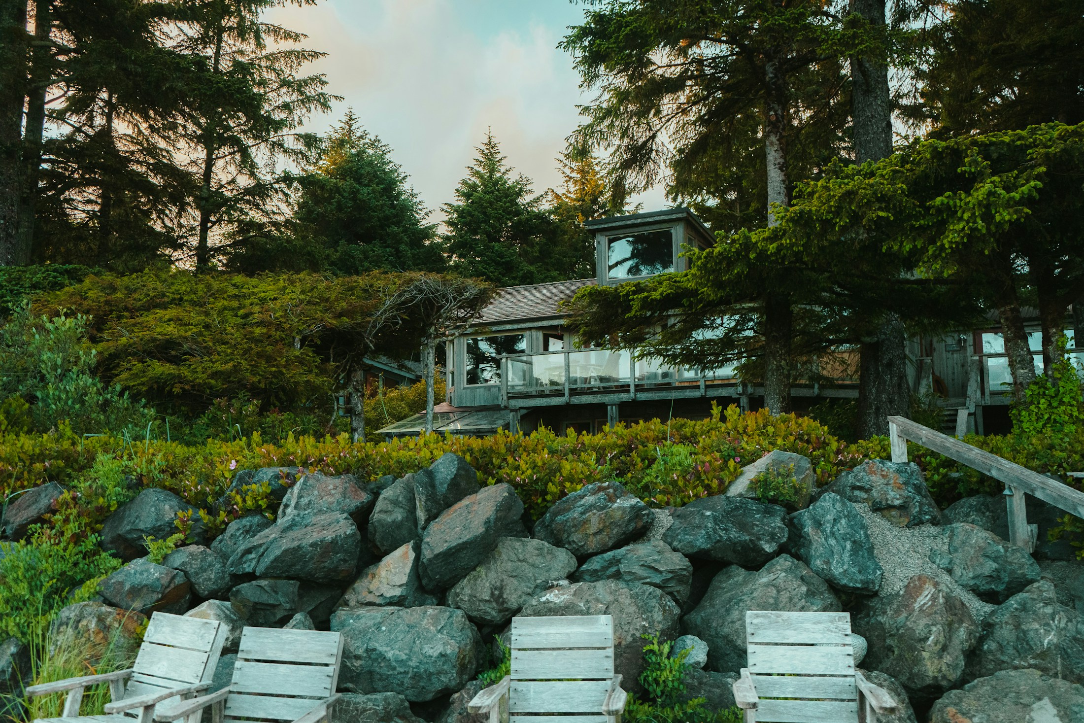 West Coast home exterior set among rocks and evergreens