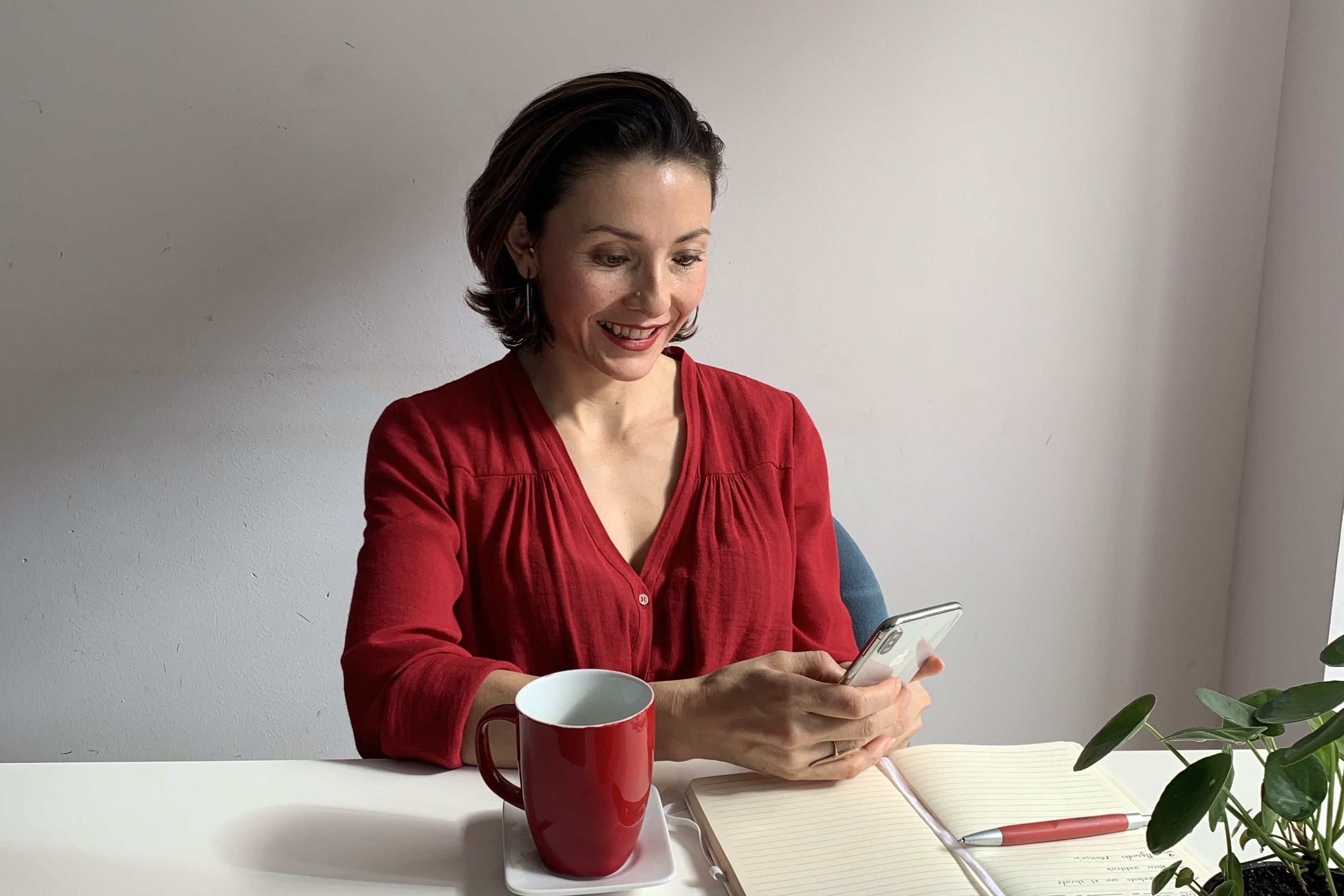 Person in beanie and sunglasses on red background.