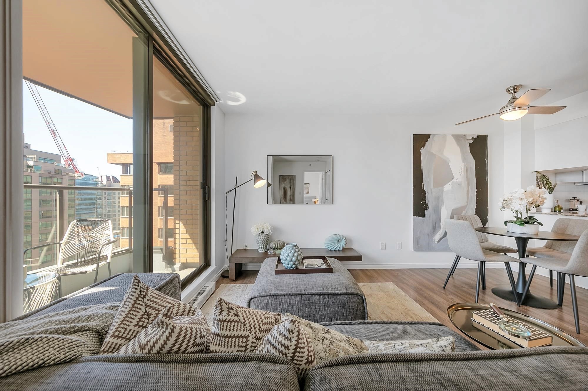 Bright and modern living room featuring large windows, cozy seating, and minimalist decor.