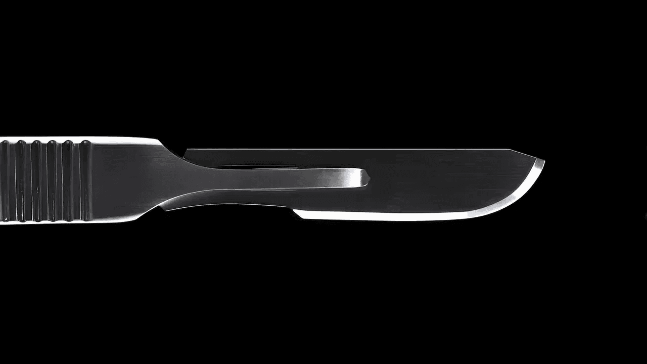 Scalpel blade against a black background, symbolizing precision, discipline, and decisive removal.