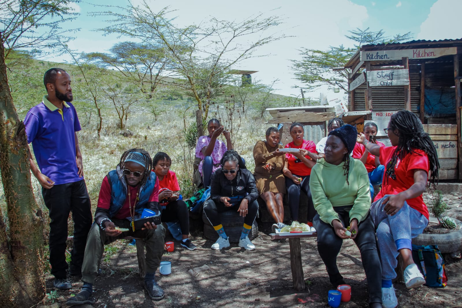 person in gray hoodie holding red and white box