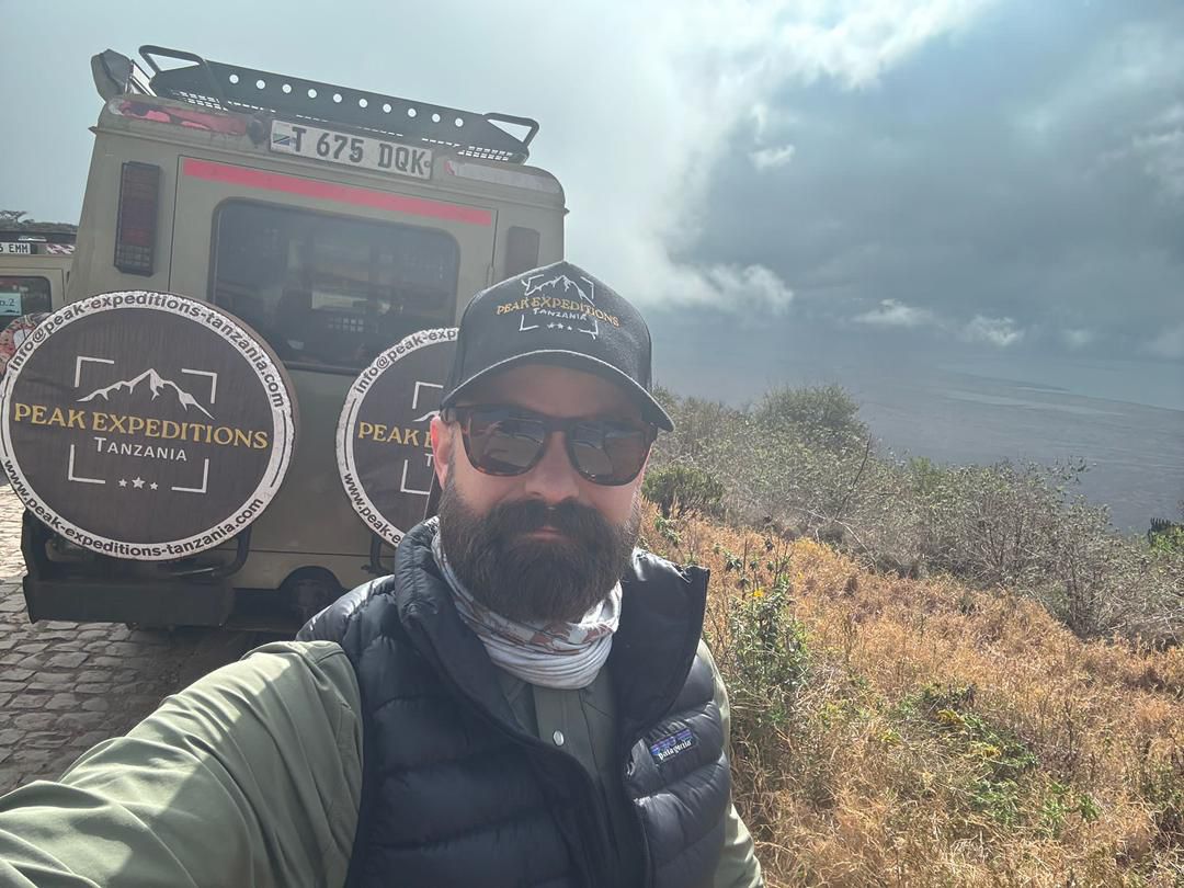 Layered desert mountains near AlUla, painted in red, beige, and orange tones under evening light.