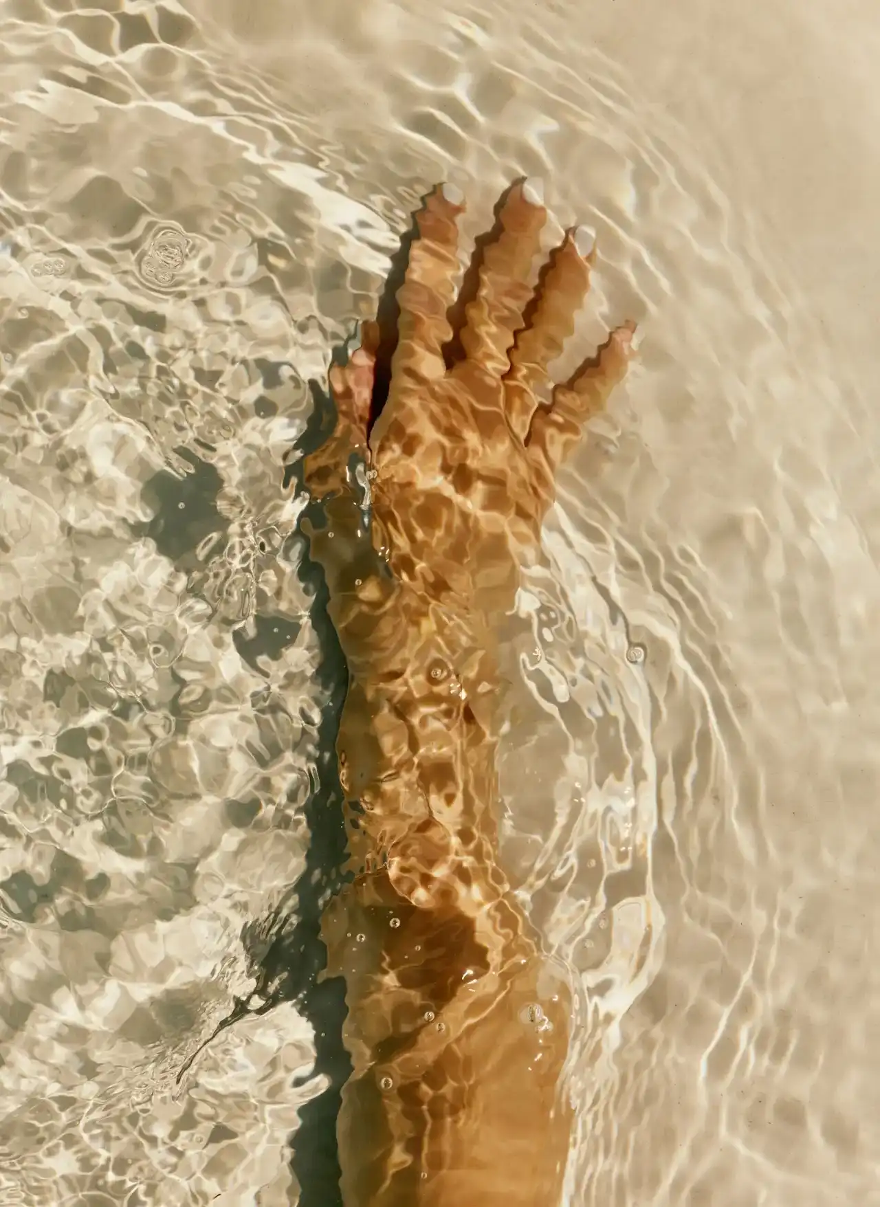 Hand moving through water, symbolizing the interconnected support, guidance, and expertise that surround each member’s health journey.
