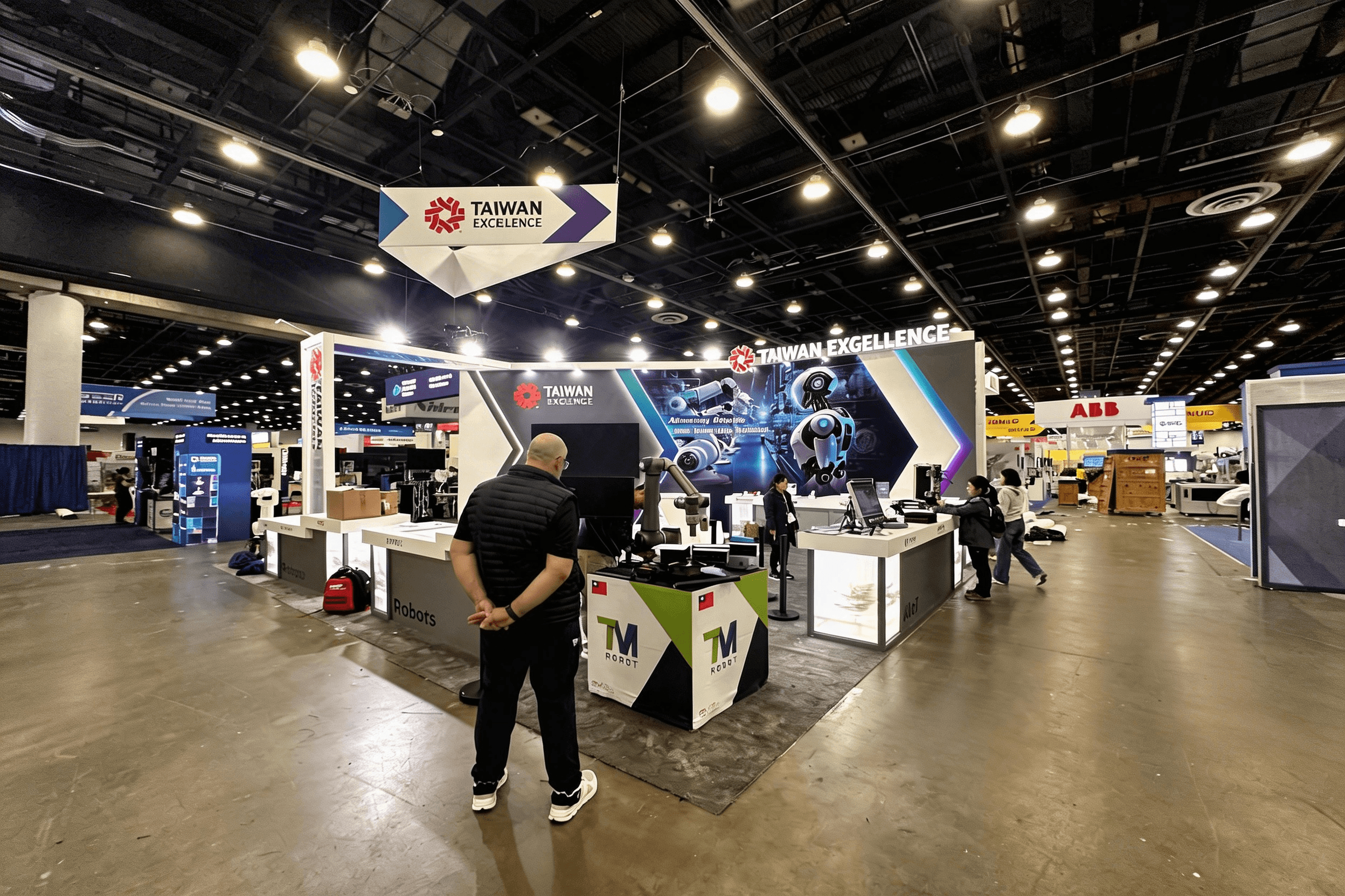 Corner view of Taiwan Excellence 10x10 booth with illuminated Robots Zone tower at Automate 2025.