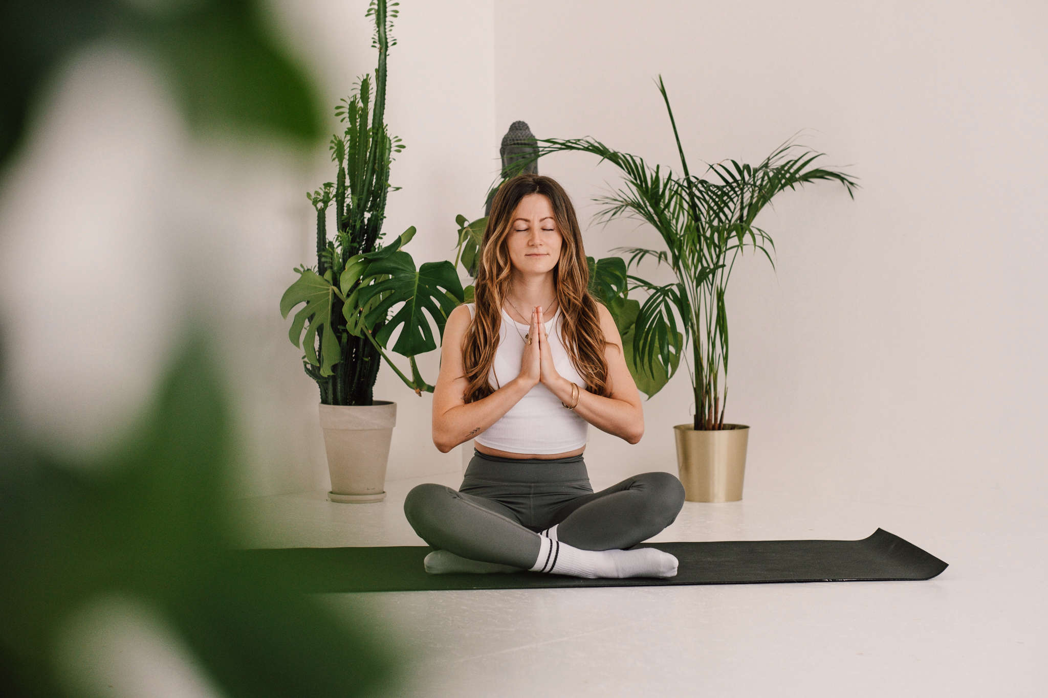 Franzi meditiert mit geschlossenen Augen auf Yogamatte