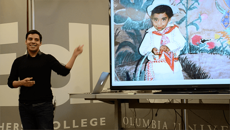 a man presenting an image displayed on a large scale tv
