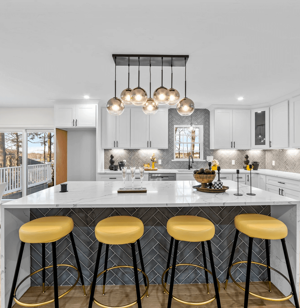 A serene outdoor seating area with two chairs, surrounded by lush greenery and a glassed-in structure.