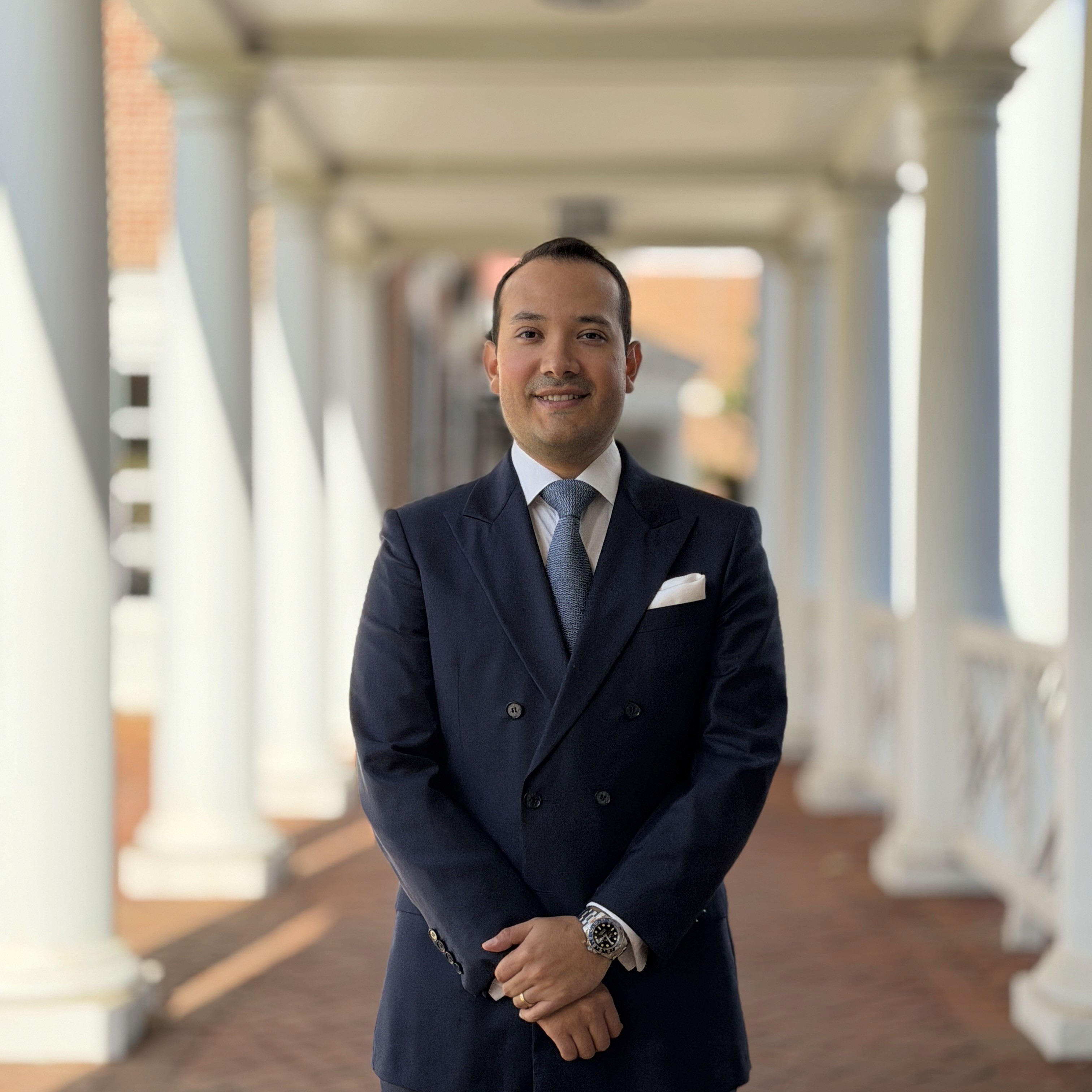 a man in a suit standing with his arms crossed