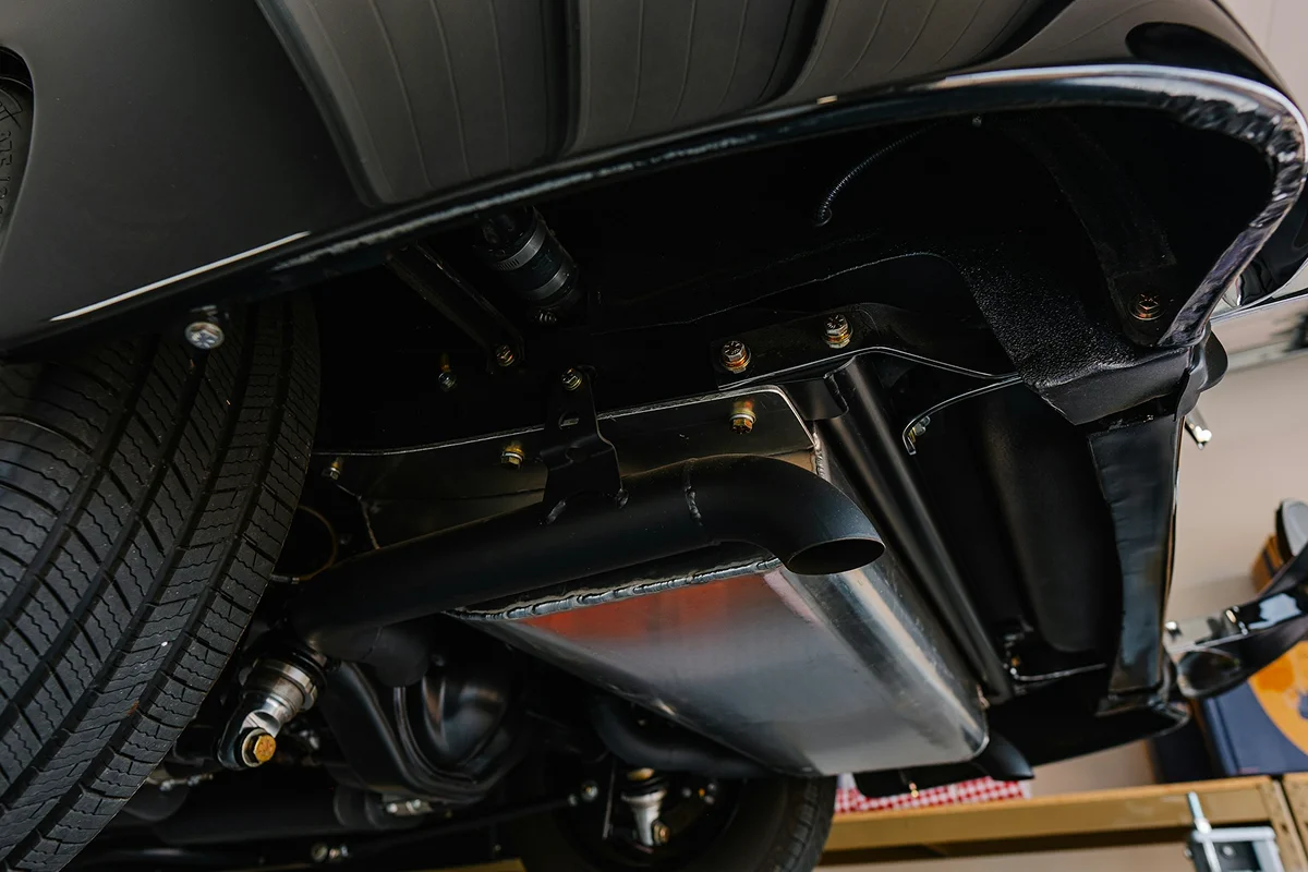 Close-up view of a vehicle underbody showing protective coating applied to chassis components