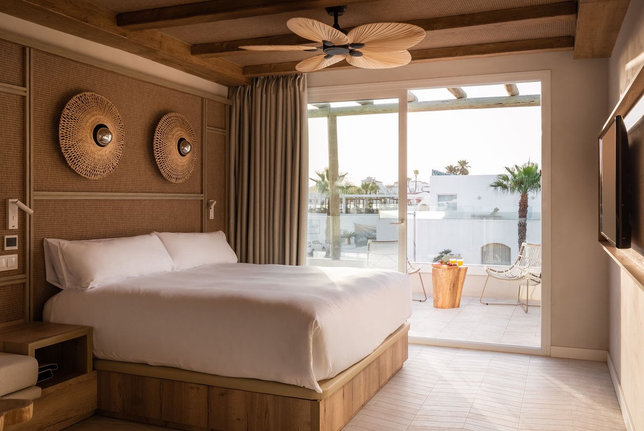 Luxuriöses Hotelzimmer mit Kingsize-Bett, Ventilator und Balkon mit Meerblick.