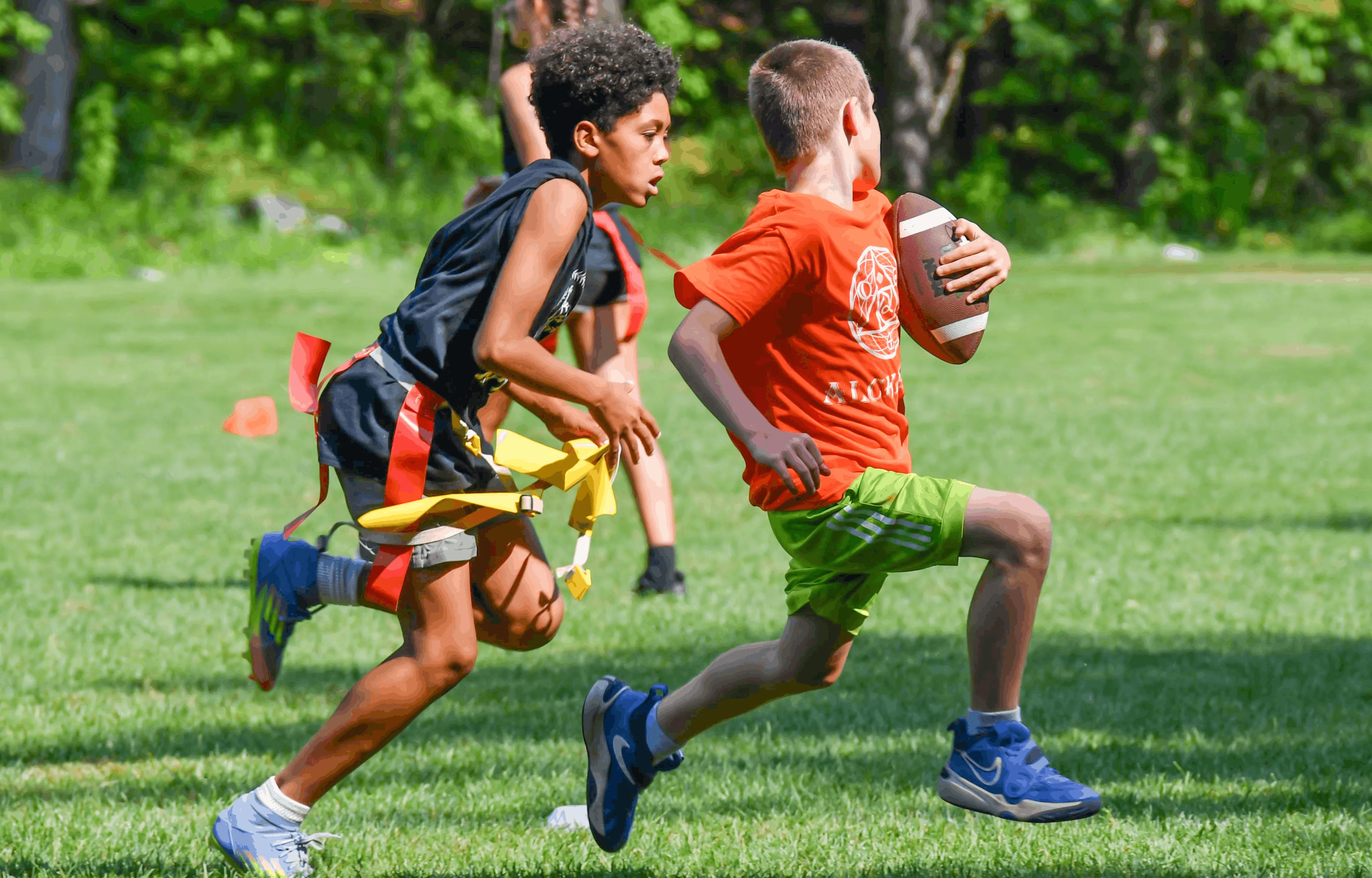 Campers competing in a flag football game on the field