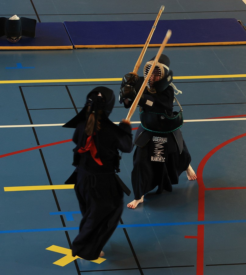 Deux adolescents pratiquant le Kendo en armure lors d’un exercice avec leur shinai.