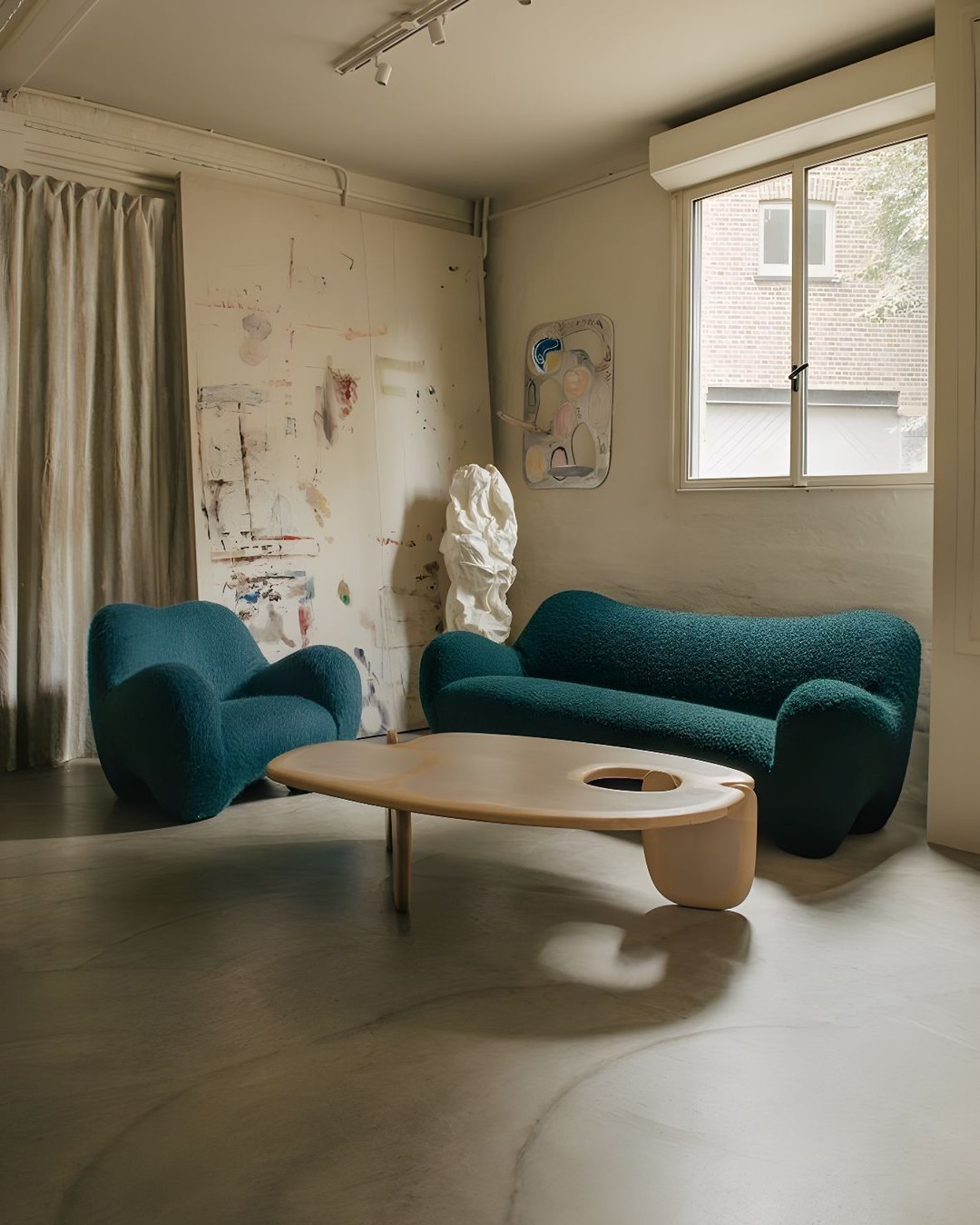 industrial, bright room with a green sofa and armchair