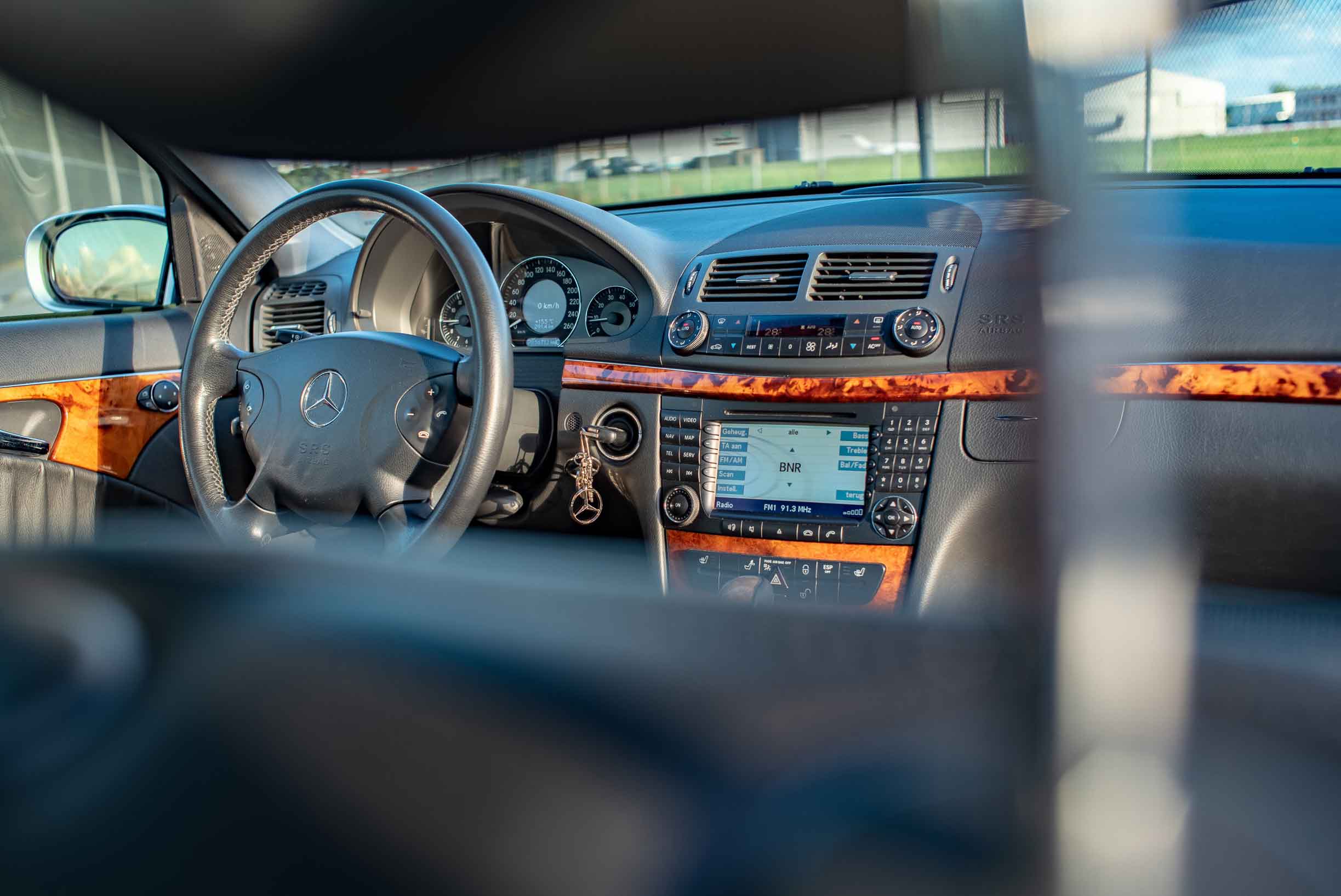 Interieur van een Mercedes-Benz E 200 Kompressor W211 met houten dashboardafwerking