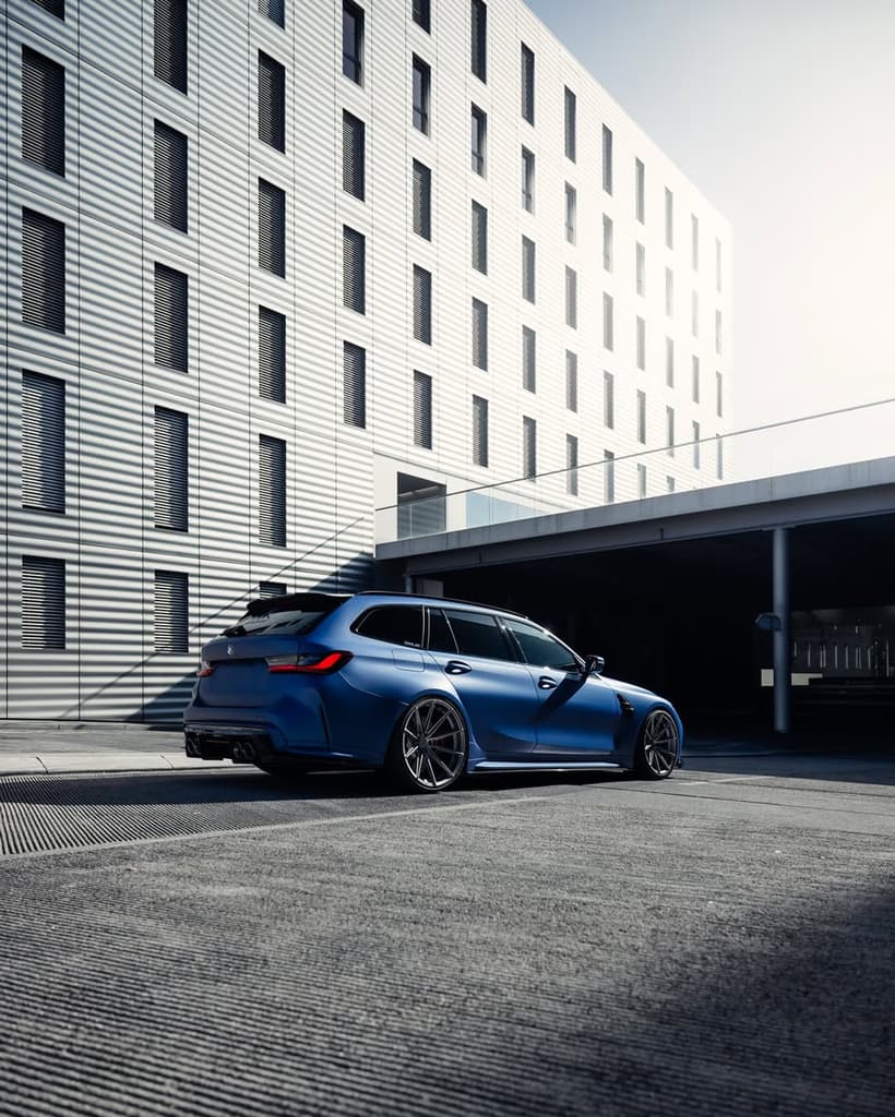 BMW M3 Touring bleue mate photographiée dans un environnement urbain moderne