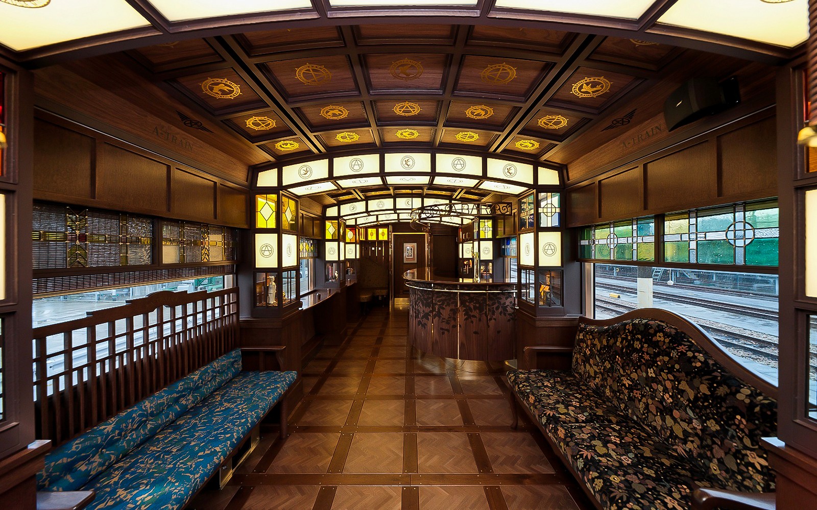 Luxurious interior of a JR North Kyushu train with wooden decor and stained glass windows.