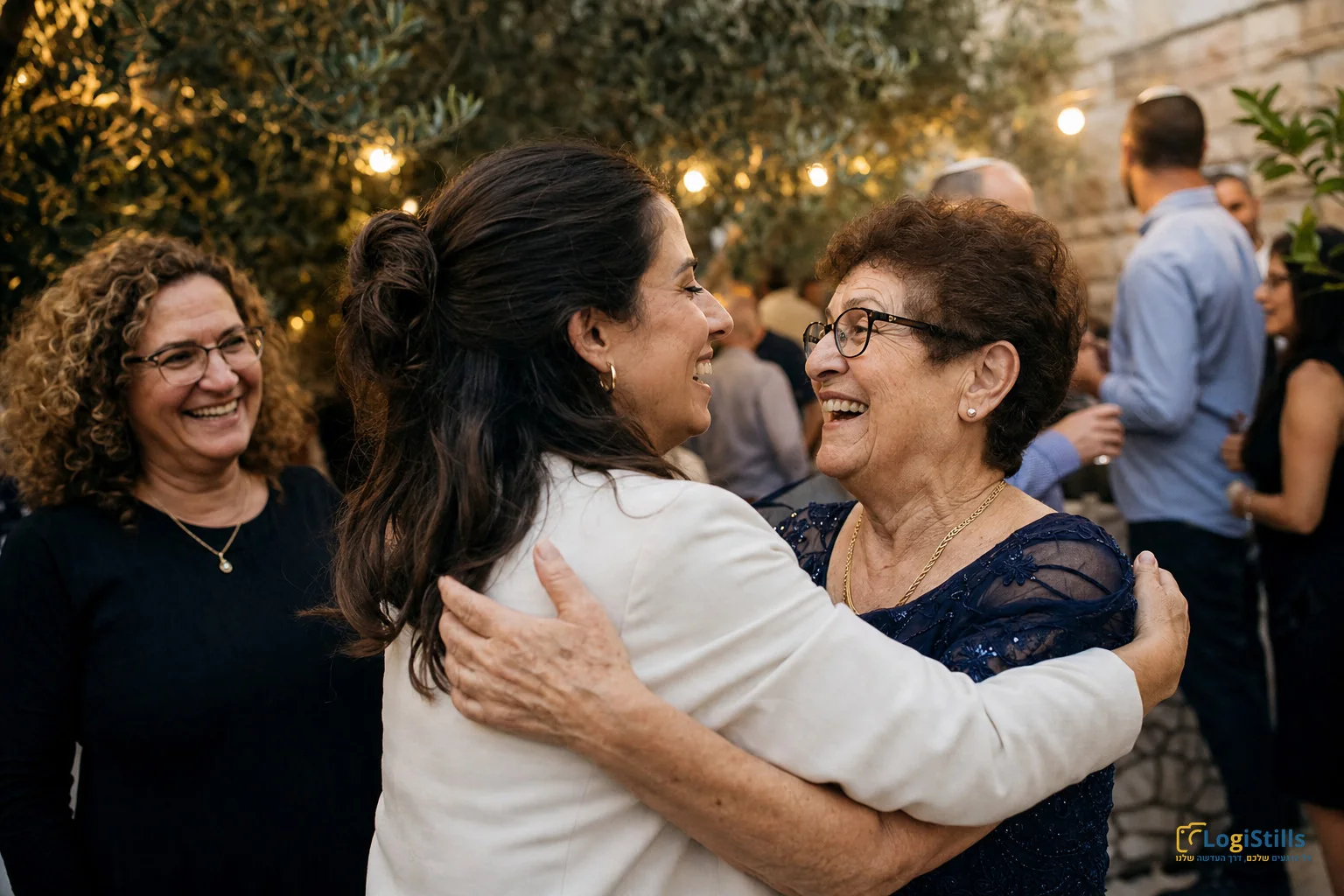 שתי נשים מתחבקות בחיוך ברגע מרגש באירוע ערב