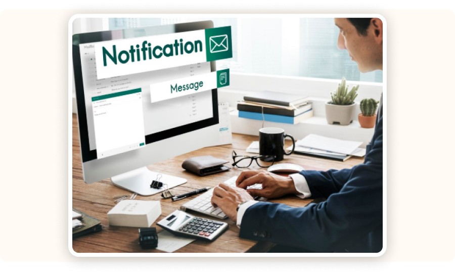Personne travaillant sur ordinateur recevant notifications et messages email.