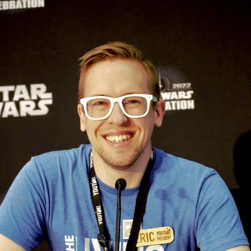 Eric Eilersen headshot in front of Star Wars Celebration sign