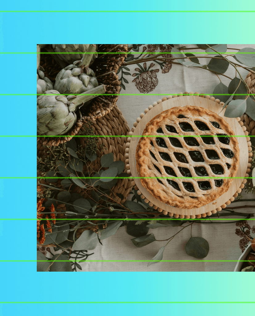 A lattice-top pie surrounded by autumn harvest vegetables and greenery.