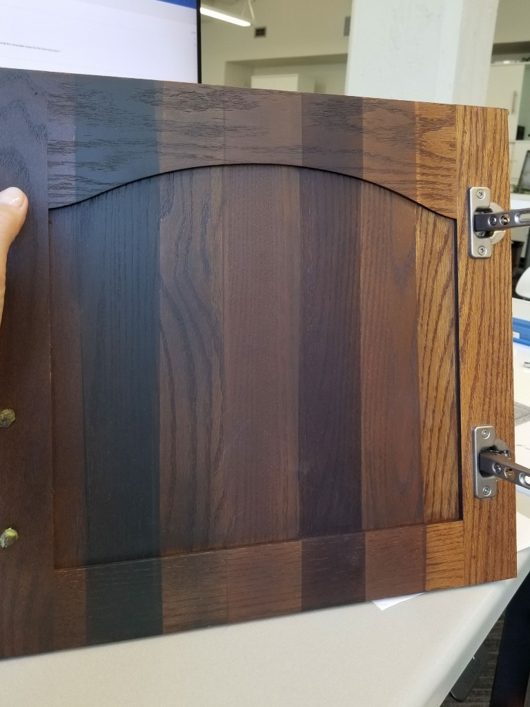 Image of KHD Homes design-build door panel with various wood tones and metal hardware for interior design construction.