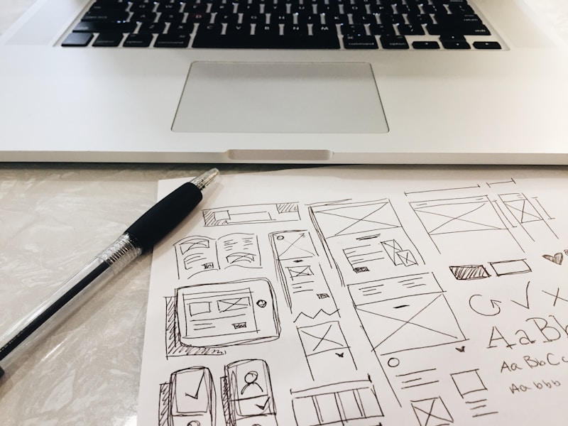 Homepage wireframes beside a laptop