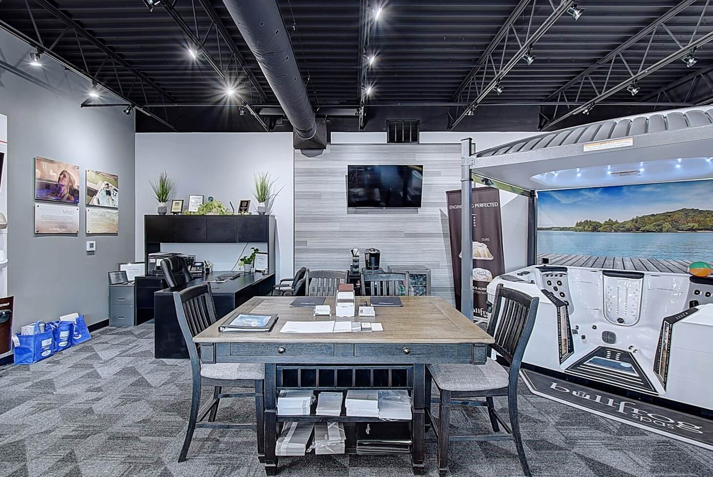 Modern room featuring a large table, chairs, and wall-mounted screen, with contemporary decor.